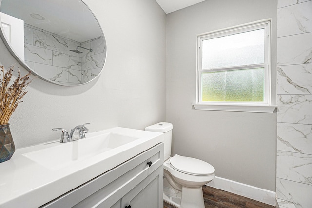 full bathroom with toilet, vanity, wood finished floors, baseboards, and walk in shower