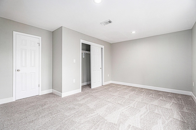 unfurnished bedroom featuring recessed lighting, light colored carpet, visible vents, baseboards, and a closet