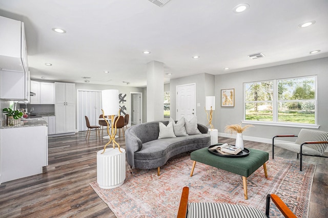 living area featuring recessed lighting, dark wood-style floors, visible vents, and baseboards