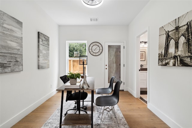 office featuring baseboards, visible vents, and light wood-style floors