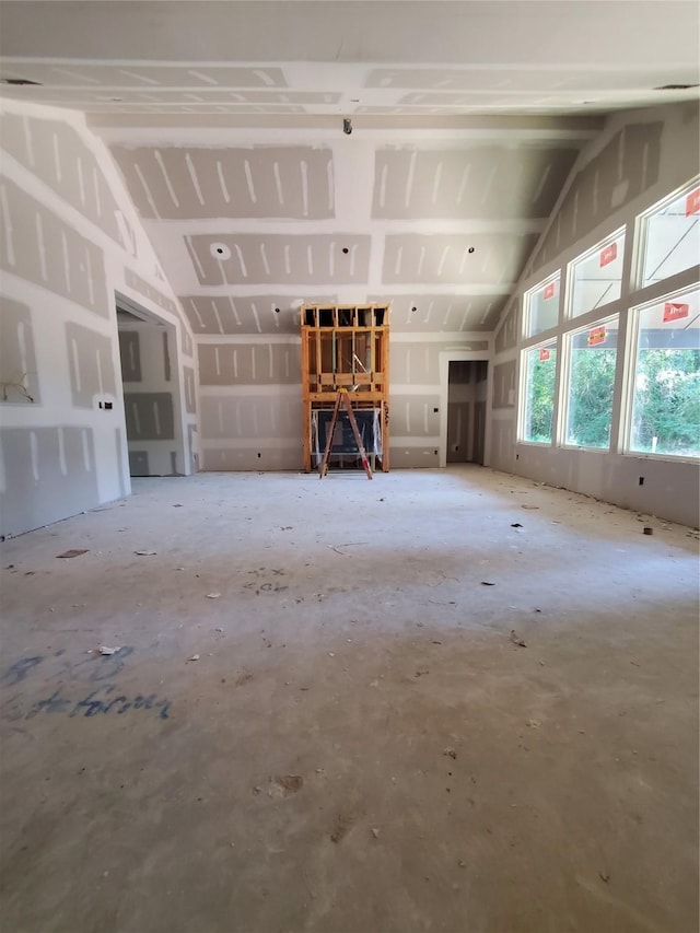 unfurnished living room featuring vaulted ceiling