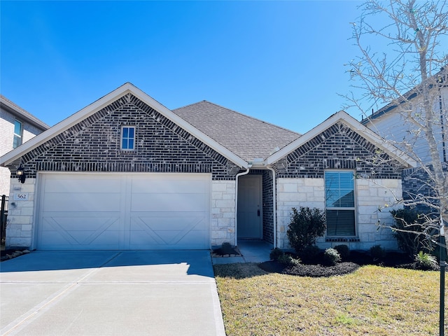 view of front of home with a garage, driveway, stone siding, roof with shingles, and a front yard