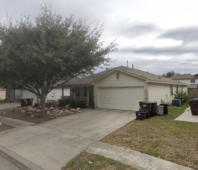 ranch-style house featuring a garage, driveway, central AC unit, and a front lawn