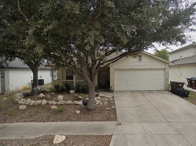 view of front facade featuring an attached garage, driveway, and central AC