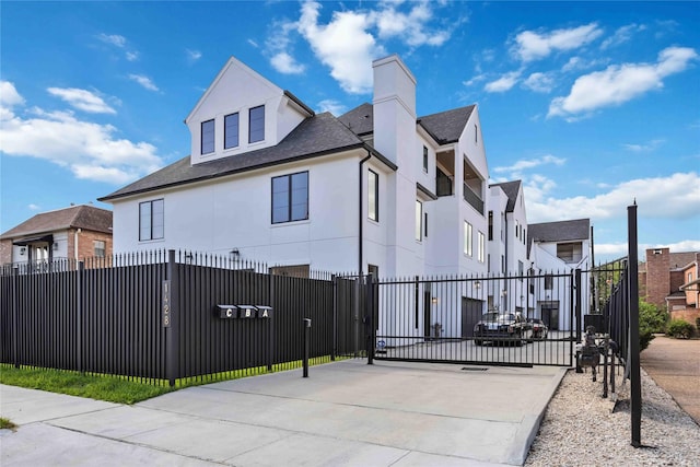 view of home's exterior featuring a fenced front yard, a gate, a residential view, and stucco siding