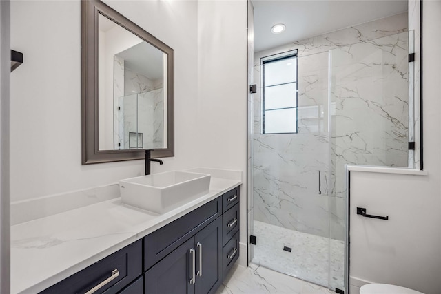 bathroom with marble finish floor, a marble finish shower, vanity, and recessed lighting