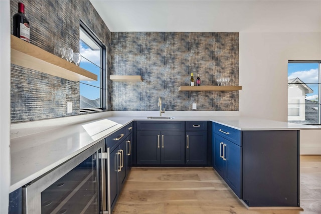 kitchen featuring open shelves, wine cooler, a peninsula, and light countertops