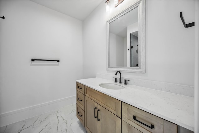 bathroom featuring marble finish floor, baseboards, and vanity