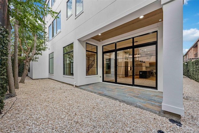 rear view of house with a patio and stucco siding