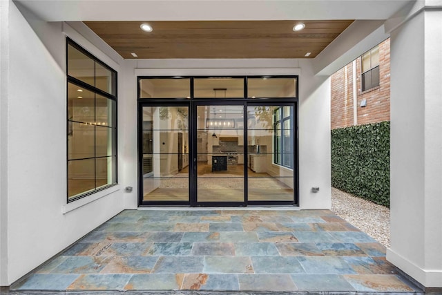 view of exterior entry with a patio area and stucco siding