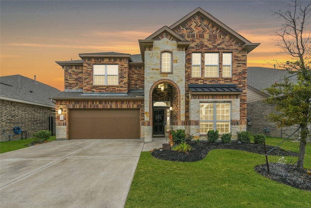 view of front of home with a yard, concrete driveway, an attached garage, a standing seam roof, and stone siding