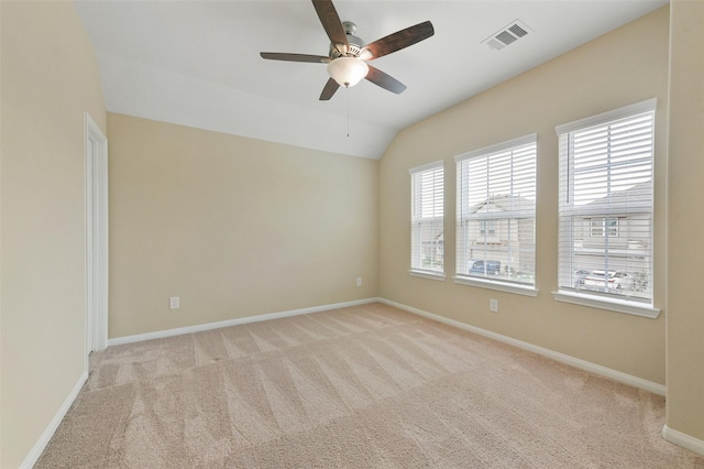 unfurnished room featuring light colored carpet, visible vents, vaulted ceiling, and baseboards