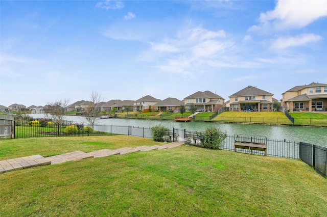 view of yard with a residential view, a water view, and a fenced backyard