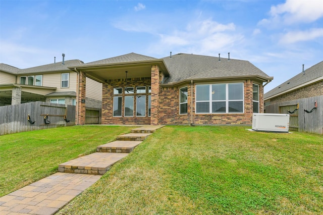 rear view of property featuring roof with shingles, fence, a lawn, and brick siding