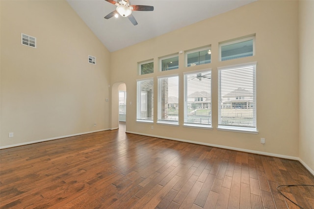 spare room with dark wood-type flooring, arched walkways, visible vents, and ceiling fan