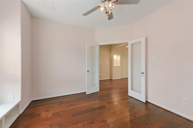 spare room featuring ceiling fan, baseboards, dark wood finished floors, and french doors