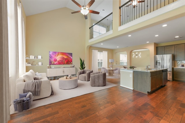 24030 Tirso River Ct, Katy, TX 77493 - living area with dark wood finished floors, a high ceiling, visible vents, ceiling fan, and arched walkways