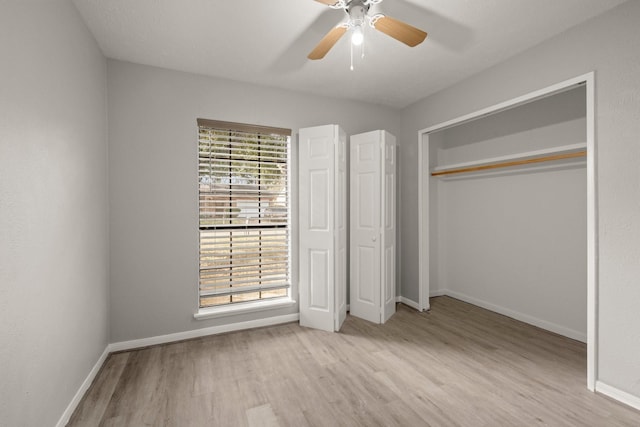 unfurnished bedroom featuring a ceiling fan, a closet, light wood-style flooring, and baseboards