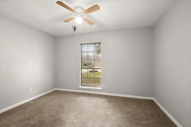 spare room with ceiling fan, carpet floors, and baseboards