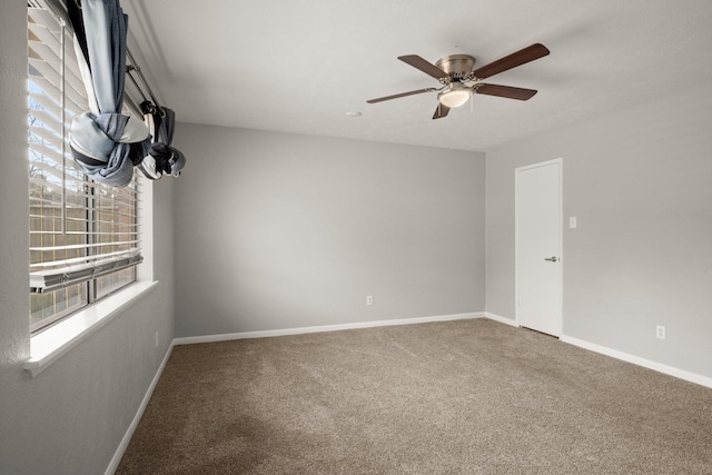 spare room with ceiling fan, carpet flooring, and baseboards