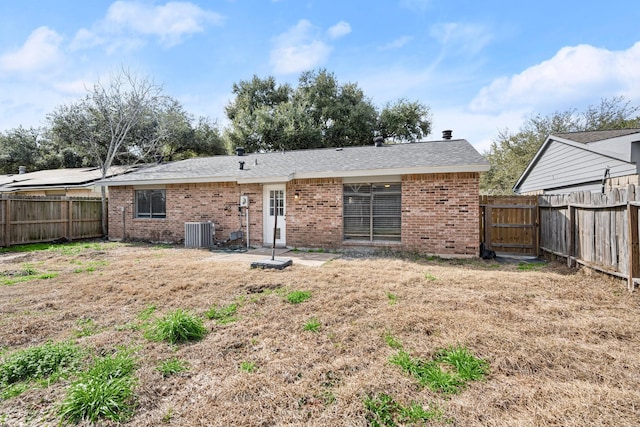 back of property featuring a fenced backyard, a gate, cooling unit, and brick siding