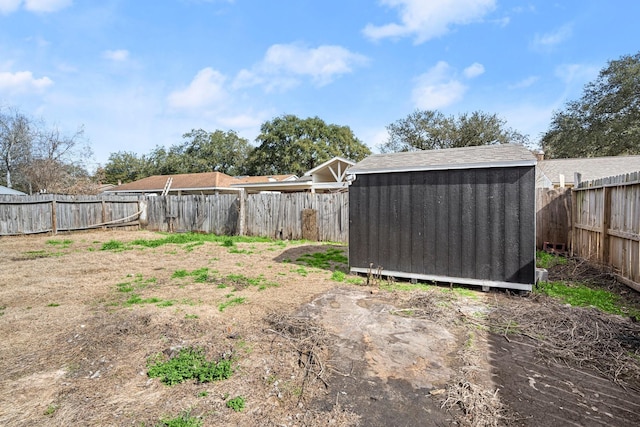 view of yard featuring a fenced backyard, a storage unit, and an outdoor structure