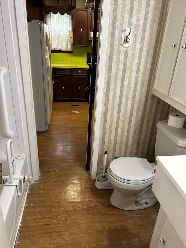 bathroom featuring wood finished floors and toilet