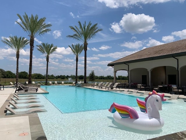 pool with a patio area and fence