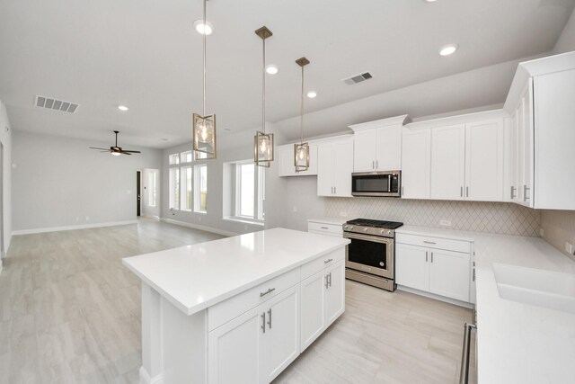 21311 Bridle Rose Trl, Tomball, TX 77377 - kitchen featuring stainless steel appliances, a kitchen island, visible vents, and decorative backsplash