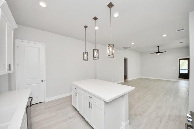 21311 Bridle Rose Trl, Tomball, TX 77377 - kitchen featuring light wood-style flooring, light countertops, a ceiling fan, white cabinets, and pendant lighting