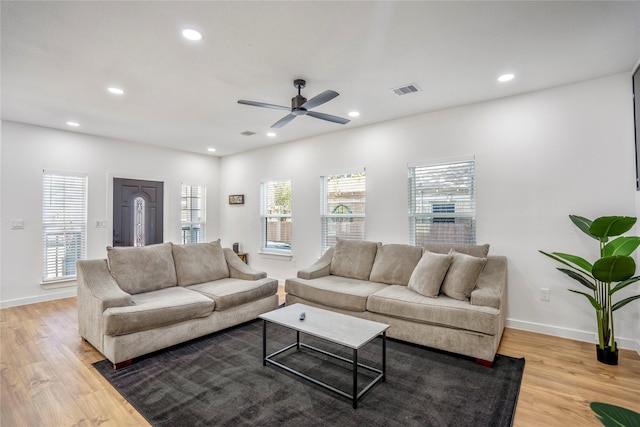 living room featuring baseboards, visible vents, light wood-style flooring, and recessed lighting