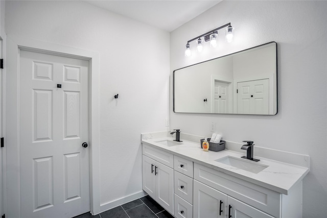 bathroom featuring double vanity, tile patterned flooring, baseboards, and a sink