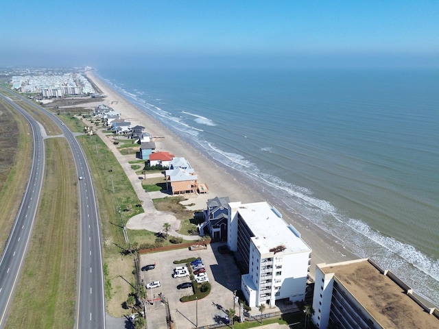 birds eye view of property with a water view and a beach view