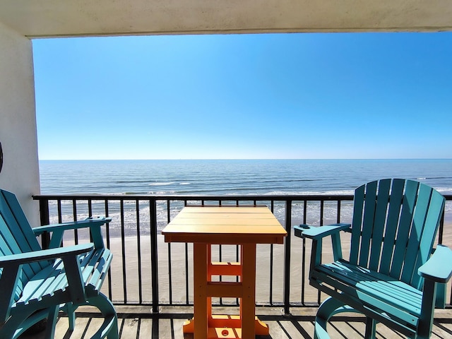 balcony featuring a beach view and a water view