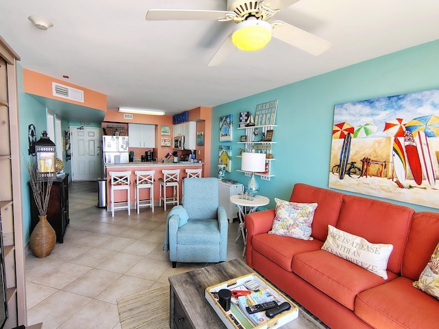 living area featuring a ceiling fan, visible vents, and tile patterned floors