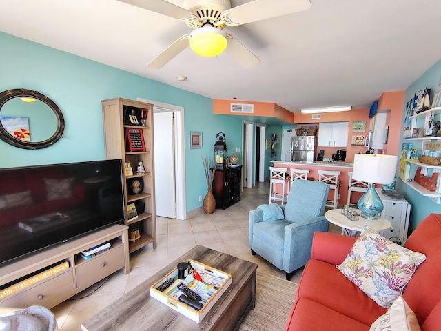 living room featuring light tile patterned flooring, visible vents, and ceiling fan