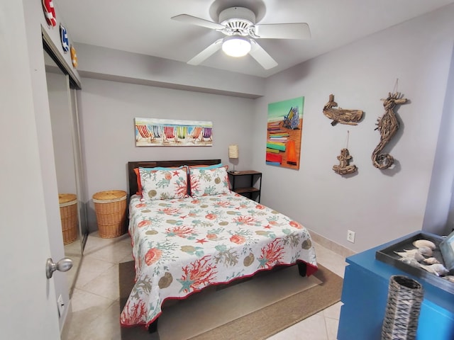 bedroom with a closet, light tile patterned flooring, and a ceiling fan