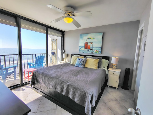 bedroom with a water view, access to exterior, floor to ceiling windows, and light tile patterned flooring