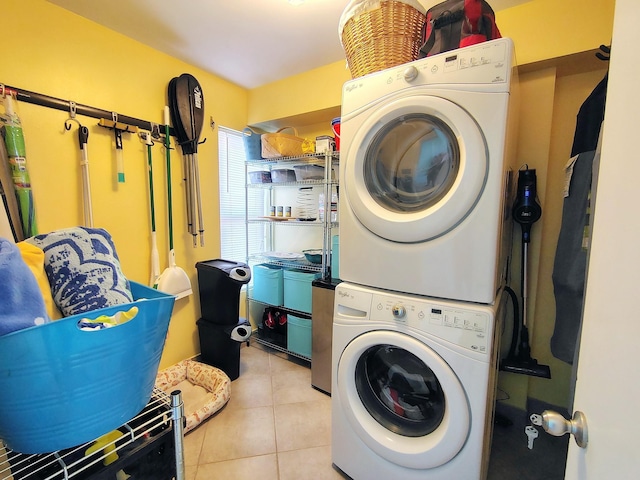 laundry room featuring light tile patterned floors, laundry area, and stacked washer and clothes dryer