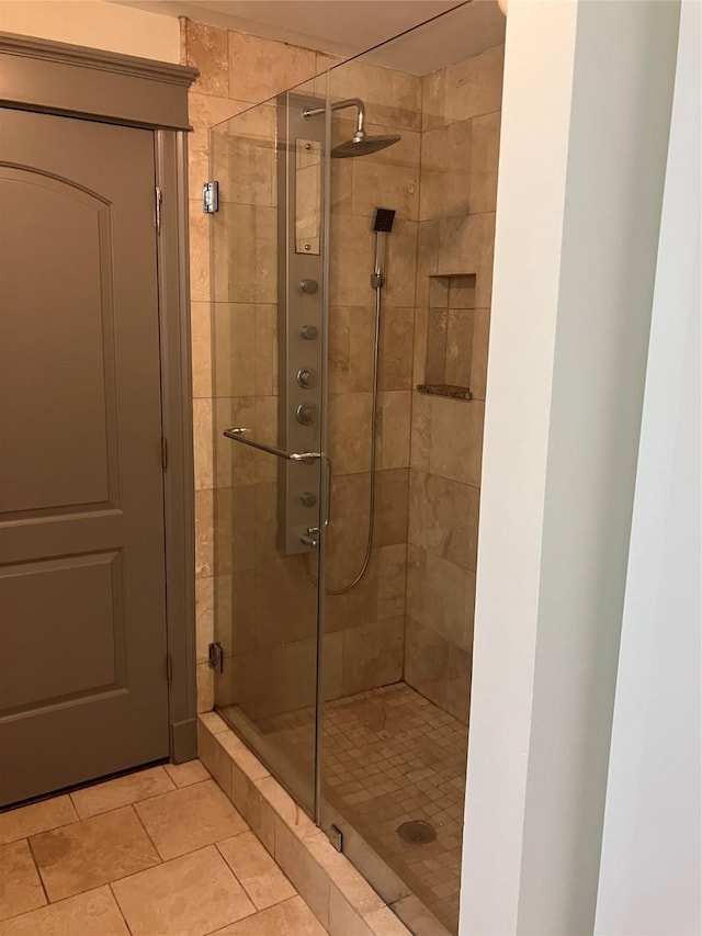 bathroom with a stall shower and tile patterned flooring