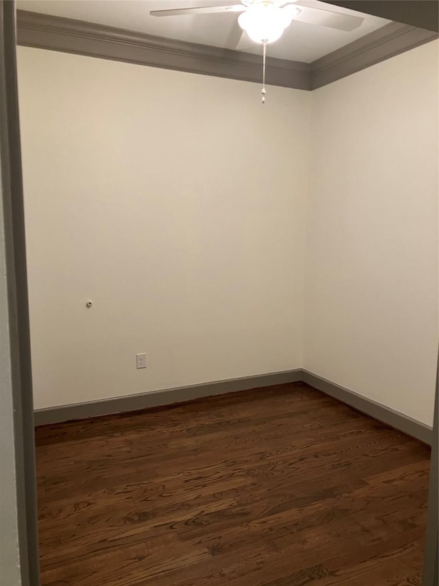 spare room featuring ornamental molding, dark wood finished floors, baseboards, and a ceiling fan