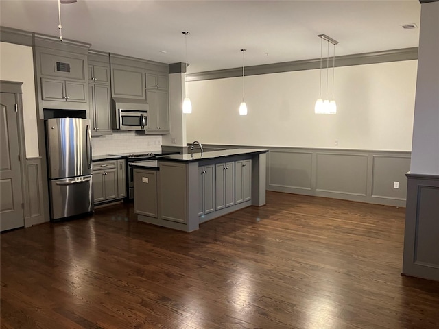 kitchen featuring dark countertops, gray cabinets, stainless steel appliances, and decorative light fixtures