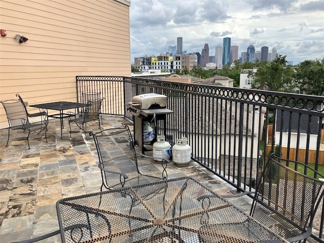 balcony featuring a grill, a view of city, and outdoor dining space