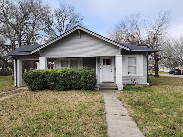 bungalow-style house featuring a shingled roof, a front yard, and covered porch