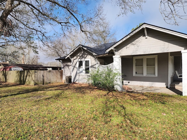 exterior space with central air condition unit, fence, and a front lawn