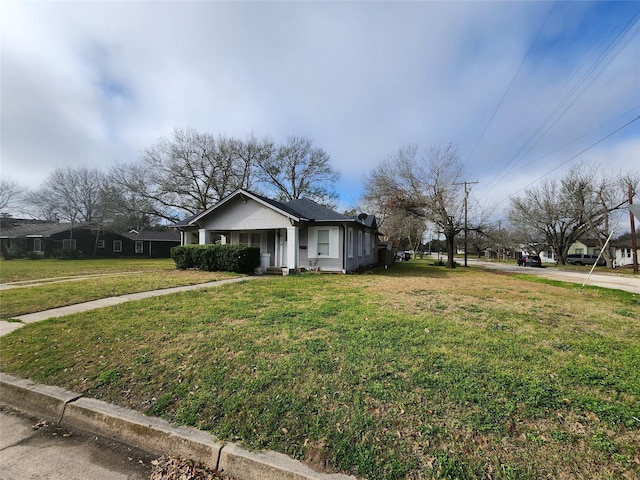 bungalow with covered porch and a front yard