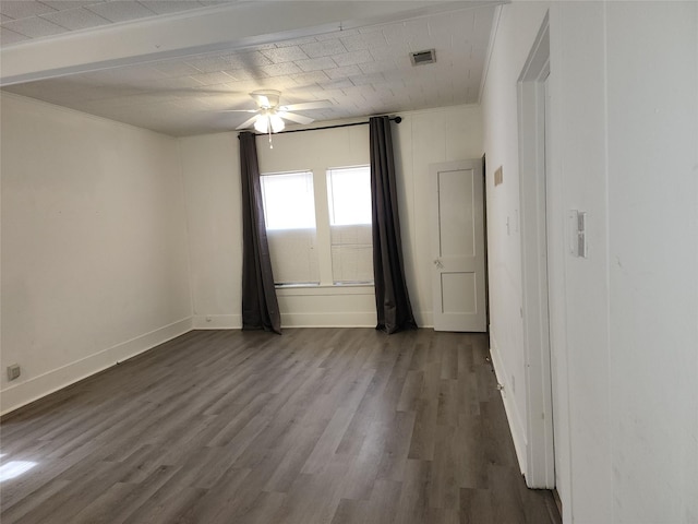 spare room with ceiling fan, visible vents, baseboards, and dark wood finished floors