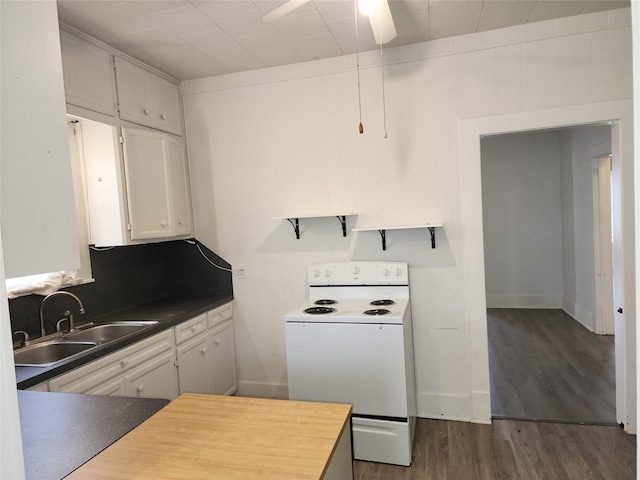 kitchen with tasteful backsplash, dark countertops, dark wood-type flooring, white electric range, and a sink