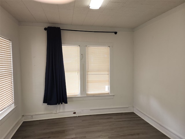 spare room with dark wood-style flooring and baseboards