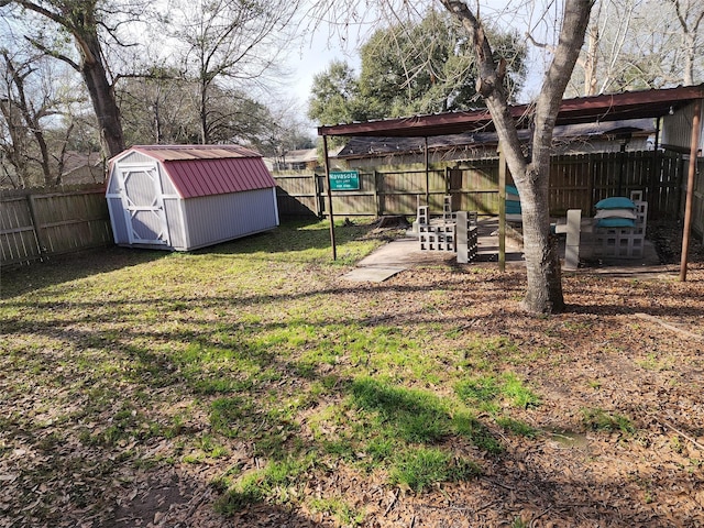 view of yard with a fenced backyard, a storage unit, and an outdoor structure